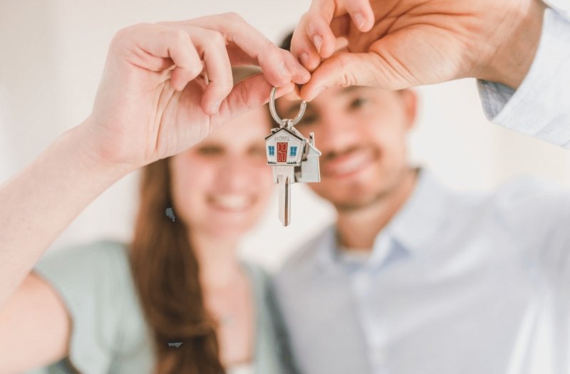 Happy couple holding the keys to their new home.