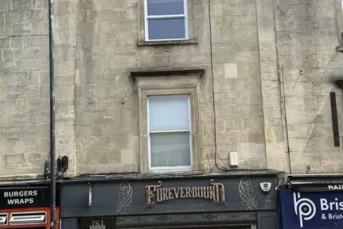 Stone-fronted period building on a high street, with a shop called "Foreverbound" on the ground floor and two residential windows above.